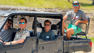 Four young men riding in an ATV