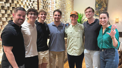 group of college age students posing for the camera in a restaurant