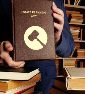 A man is holding a book titled estate planning law