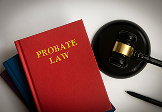 A red book titled probate law next to a judge 's gavel and a pen.