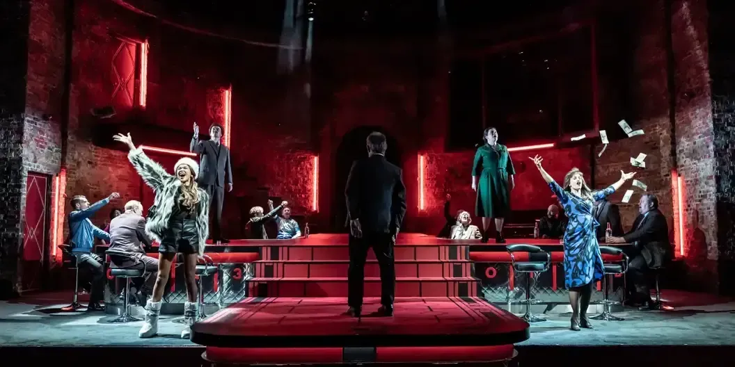 A group of people are standing on a stage in a dark room.