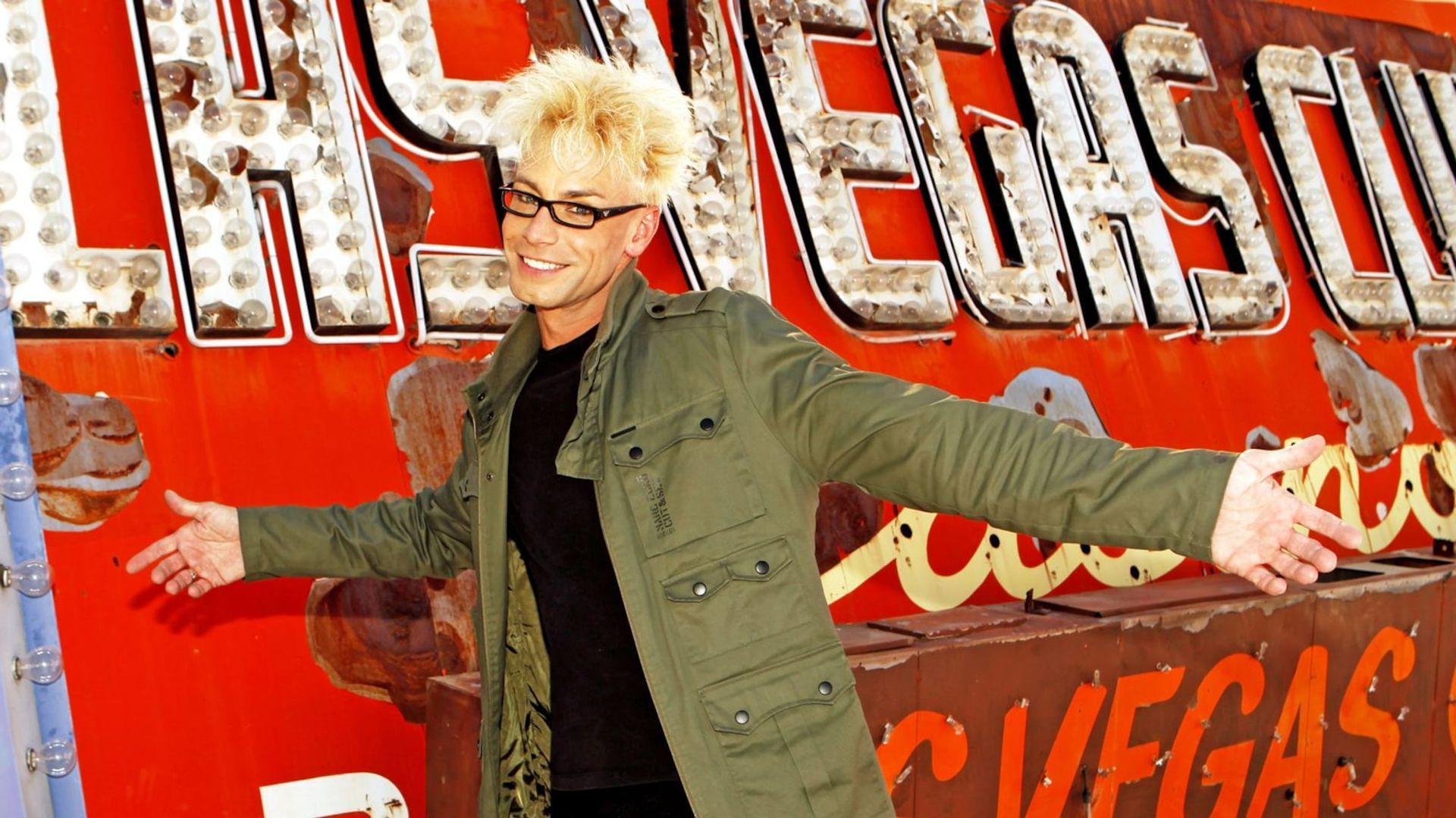 a man is standing in front of a sign that says las vegas