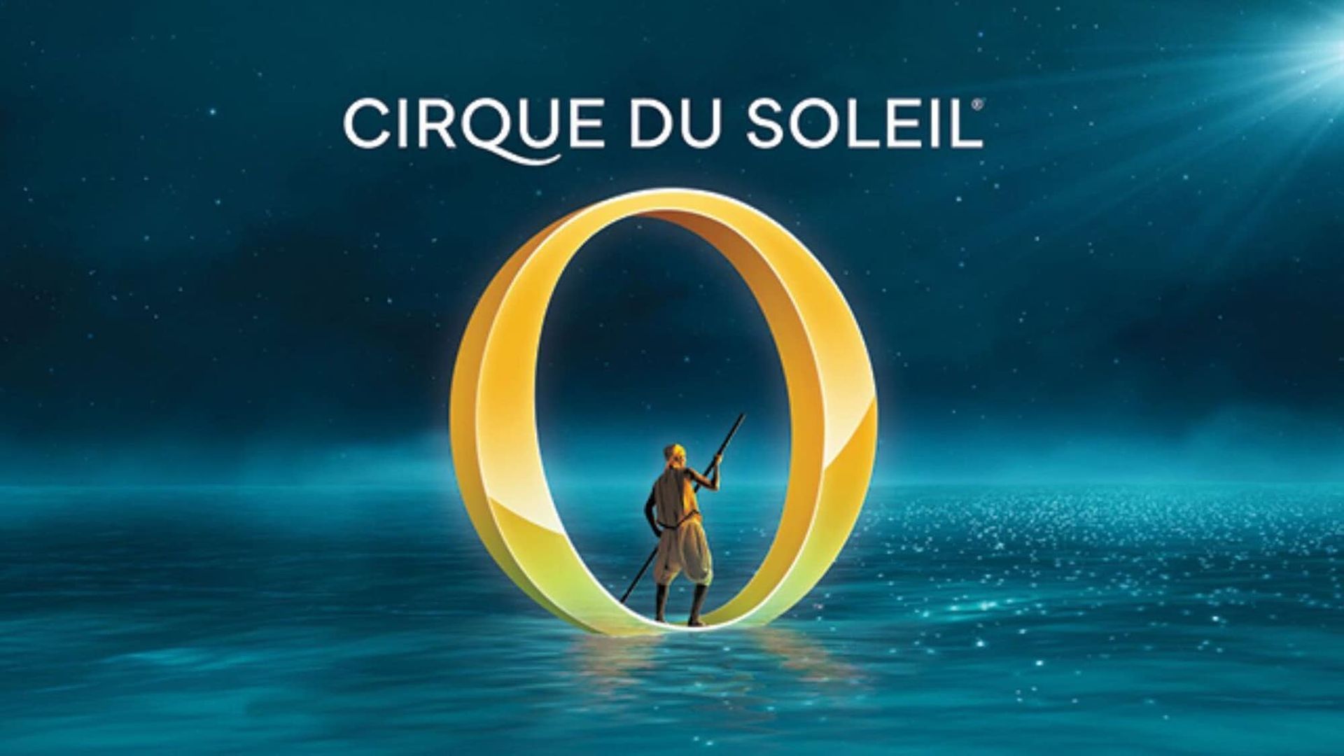 a man is standing in the middle of a large ring in the water .