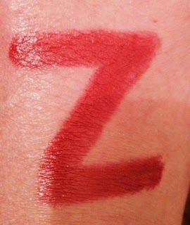 The letter z is written in red lipstick on a person 's arm