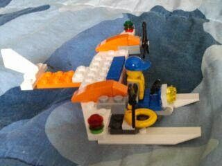 A lego airplane is sitting on a blue blanket