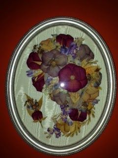 A picture of pressed flowers in a silver frame