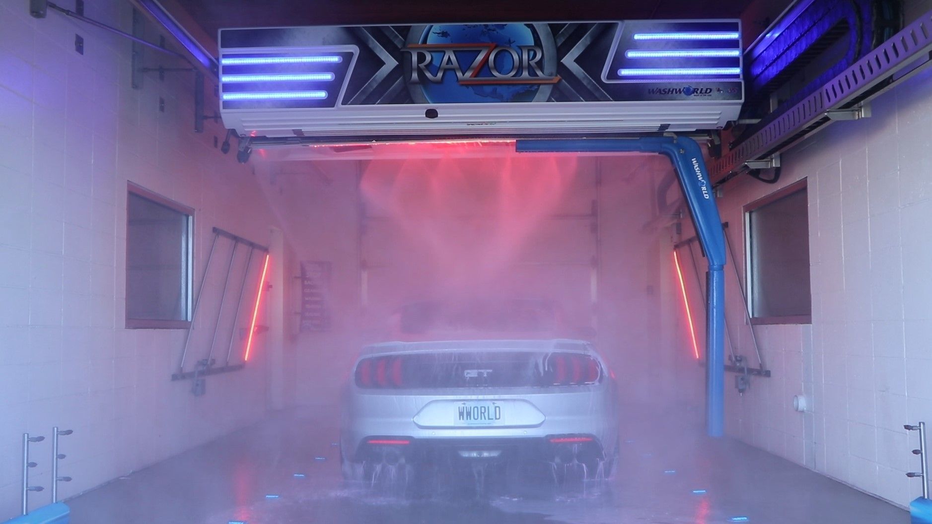 White car being washed inside a Razor car wash bay.