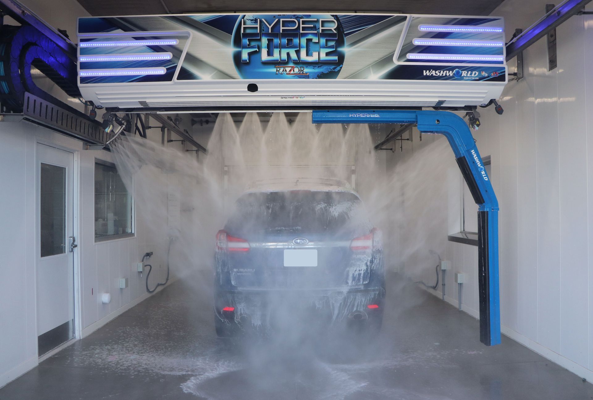 Car being washed inside a HyperForce automatic car wash bay.