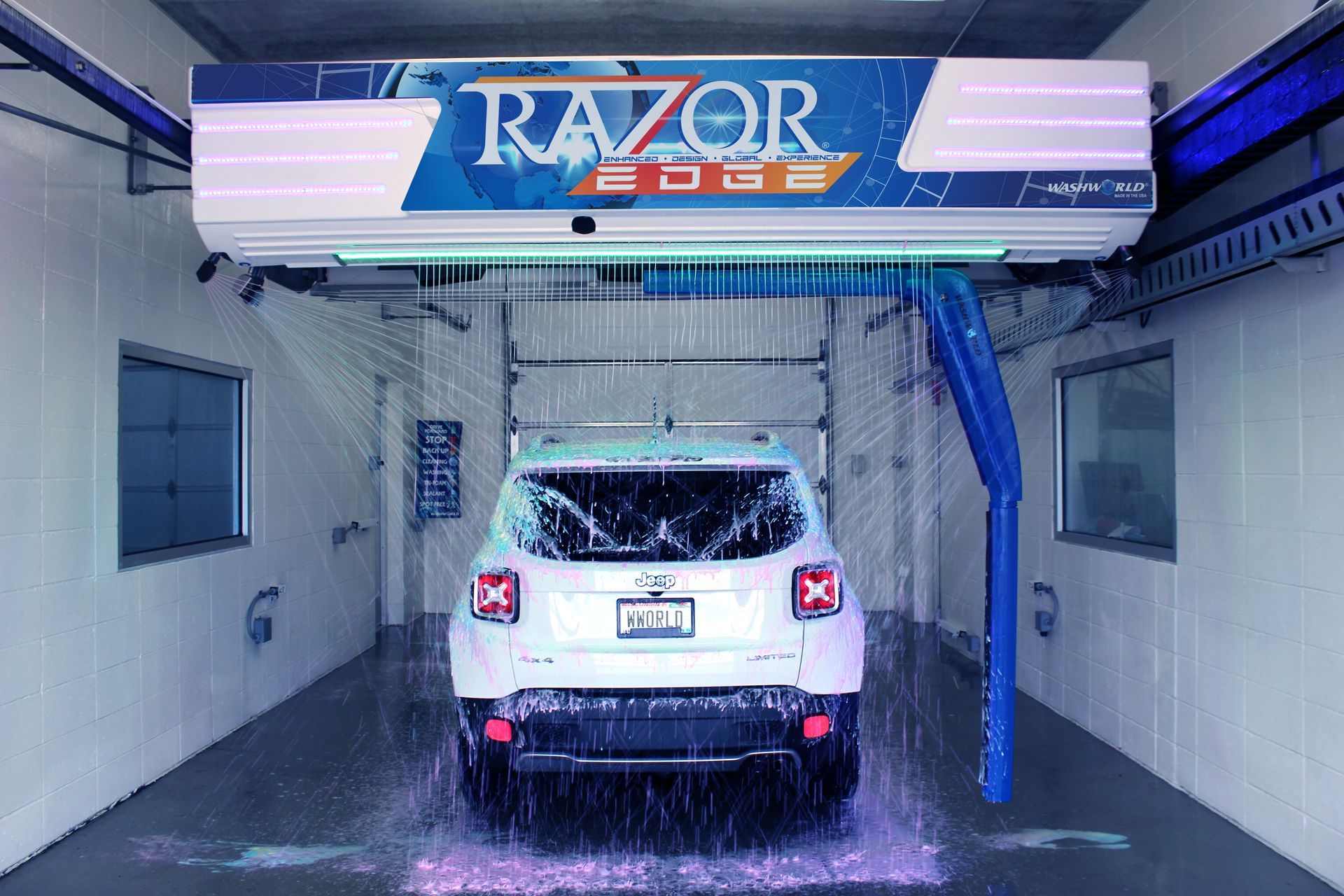White SUV inside a Razor EDGE car wash bay, being sprayed with water. 