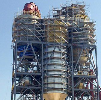 Large spacecraft booster on a launch pad surrounded by scaffolding under a clear sky