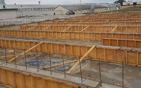 Industrial construction site with rows of wooden formwork for concrete foundations