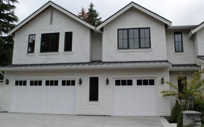 White suburban townhouse with two garage doors and black-trimmed windows