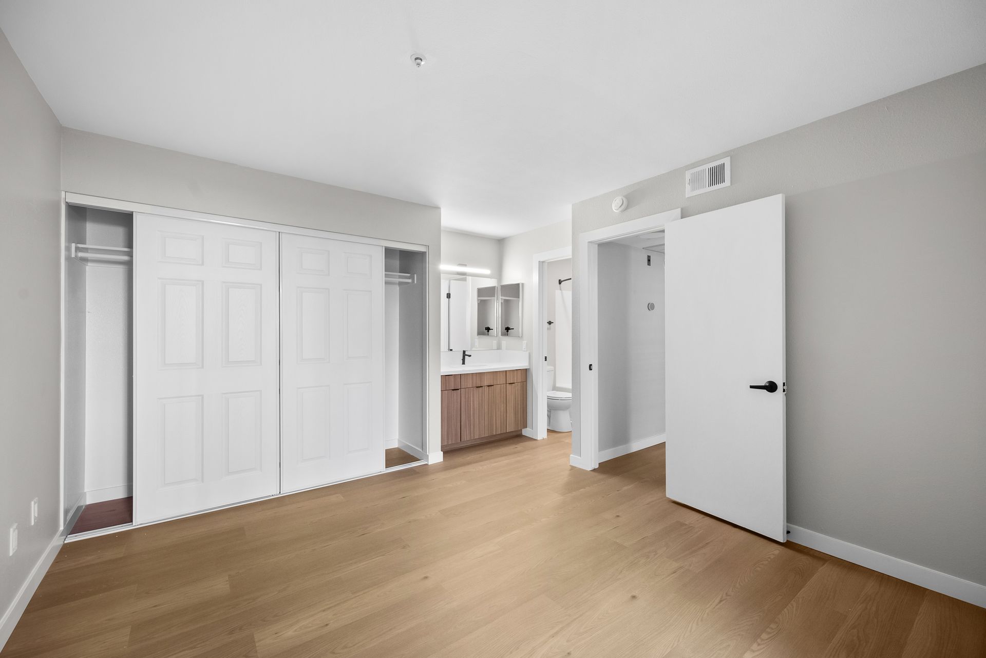 apartment bedroom at Newhope Village with wide sliding closet, an open door, and a wood counter