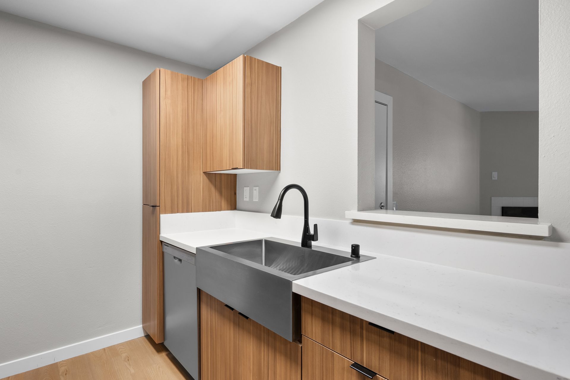 apartment kitchen at Newhope Village with farmhouse sink, stainless steel dishwasher, and wood cabinets
