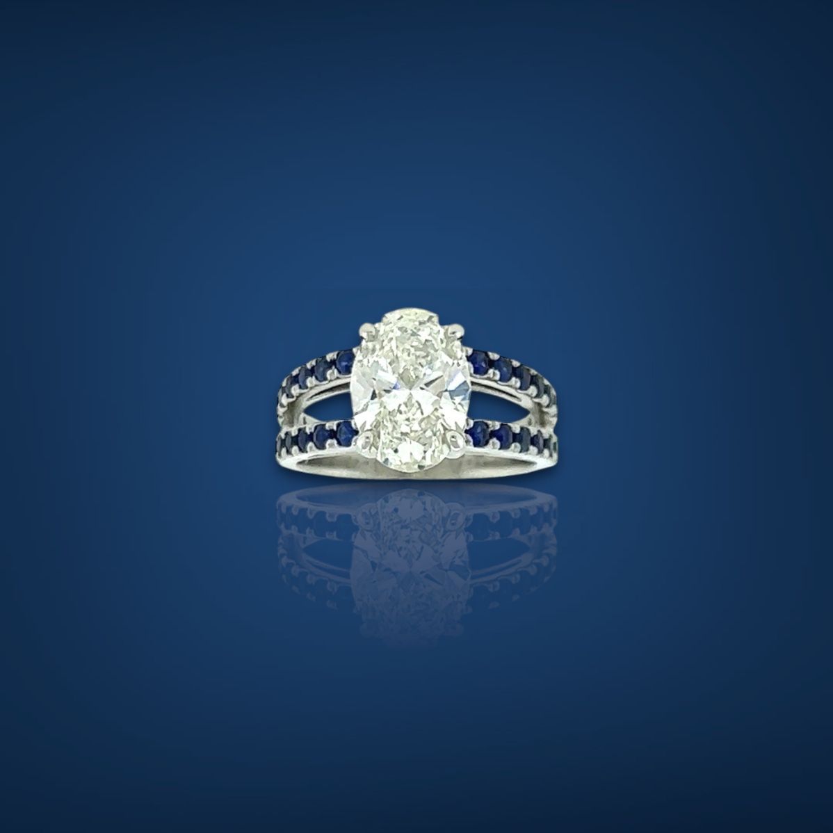 Oval diamond ring with sapphire accents on a blue background.