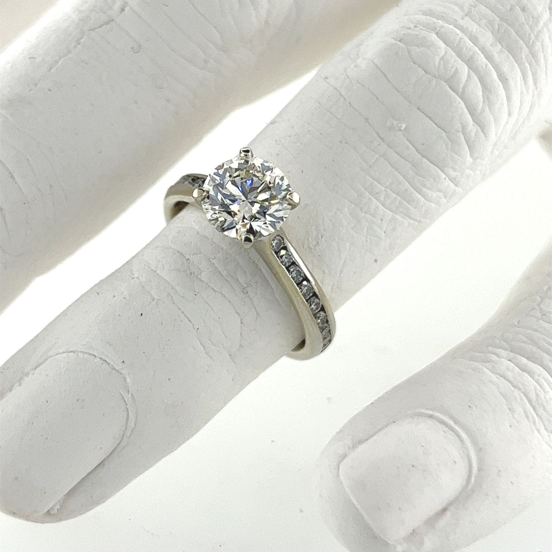 A white hand with a diamond ring on it