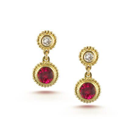 A pair of gold earrings with a red stone and diamonds.