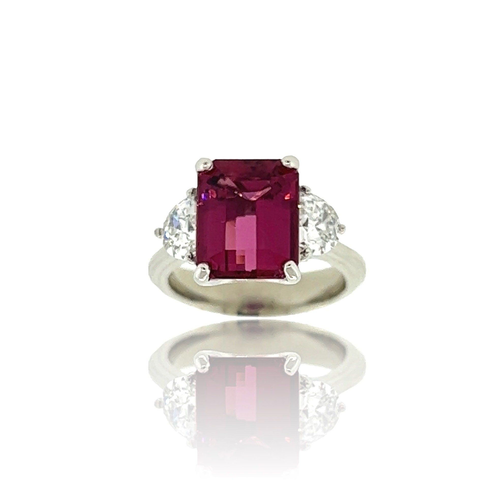 A white gold ring with a ruby and diamonds on a white background.