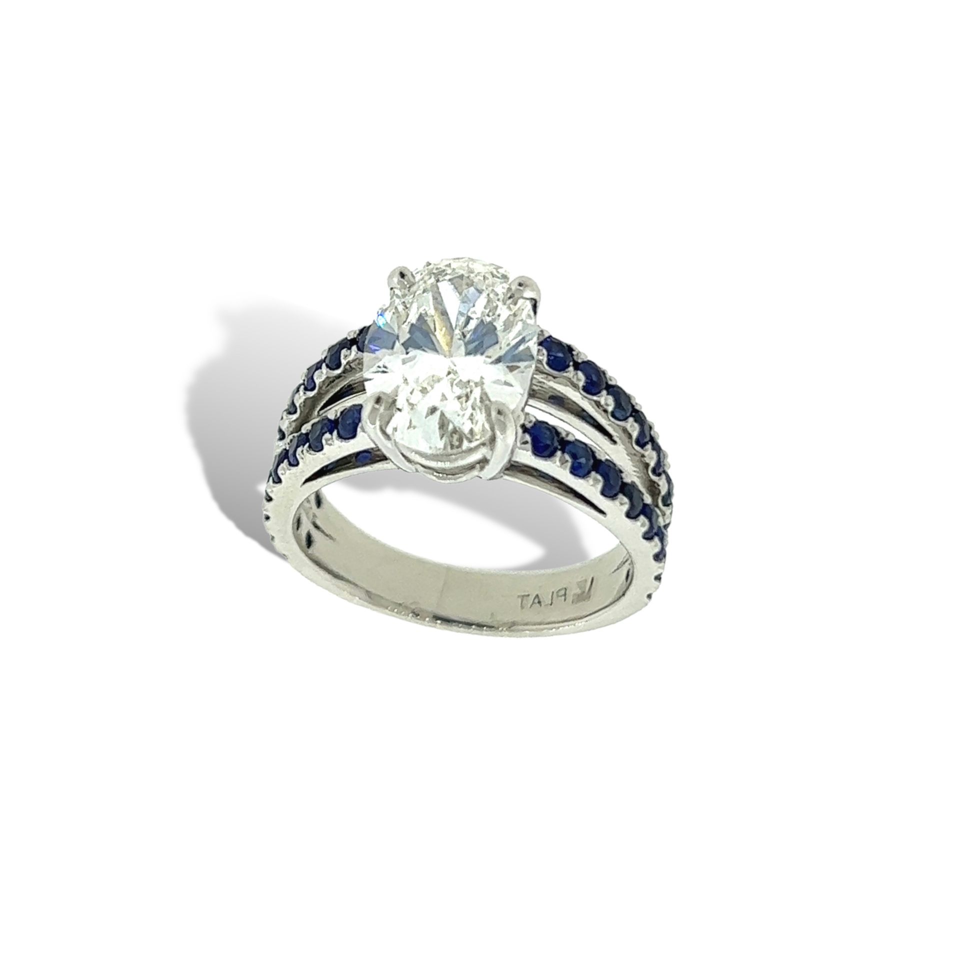A white gold ring with a diamond and blue sapphires