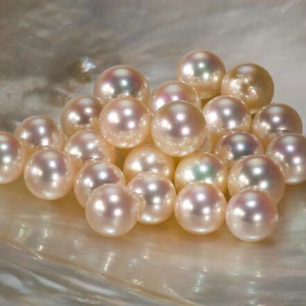A bunch of pearls are sitting on a white surface.