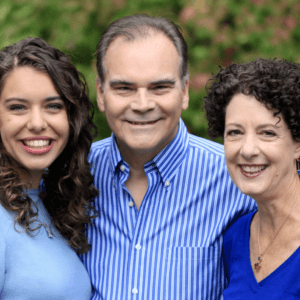 A man and two women are posing for a picture and smiling