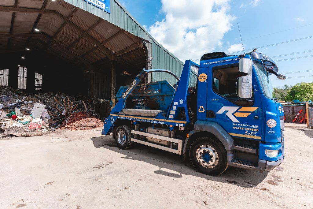 ry recycling skip lorry dropping off waste at their business site