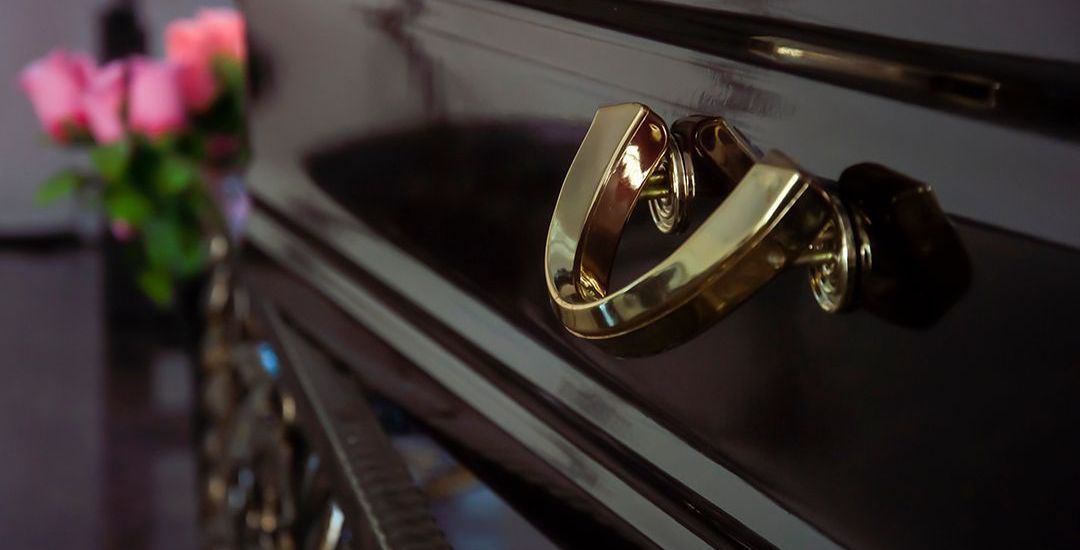 a close up of a black coffin with a gold handle
