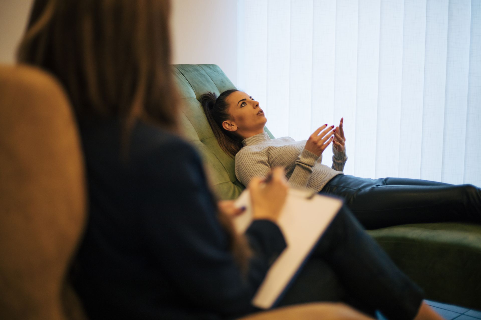 Een vrouw die op een zetel ligt tijdens het ontvangen van een sessie hypnotherapie