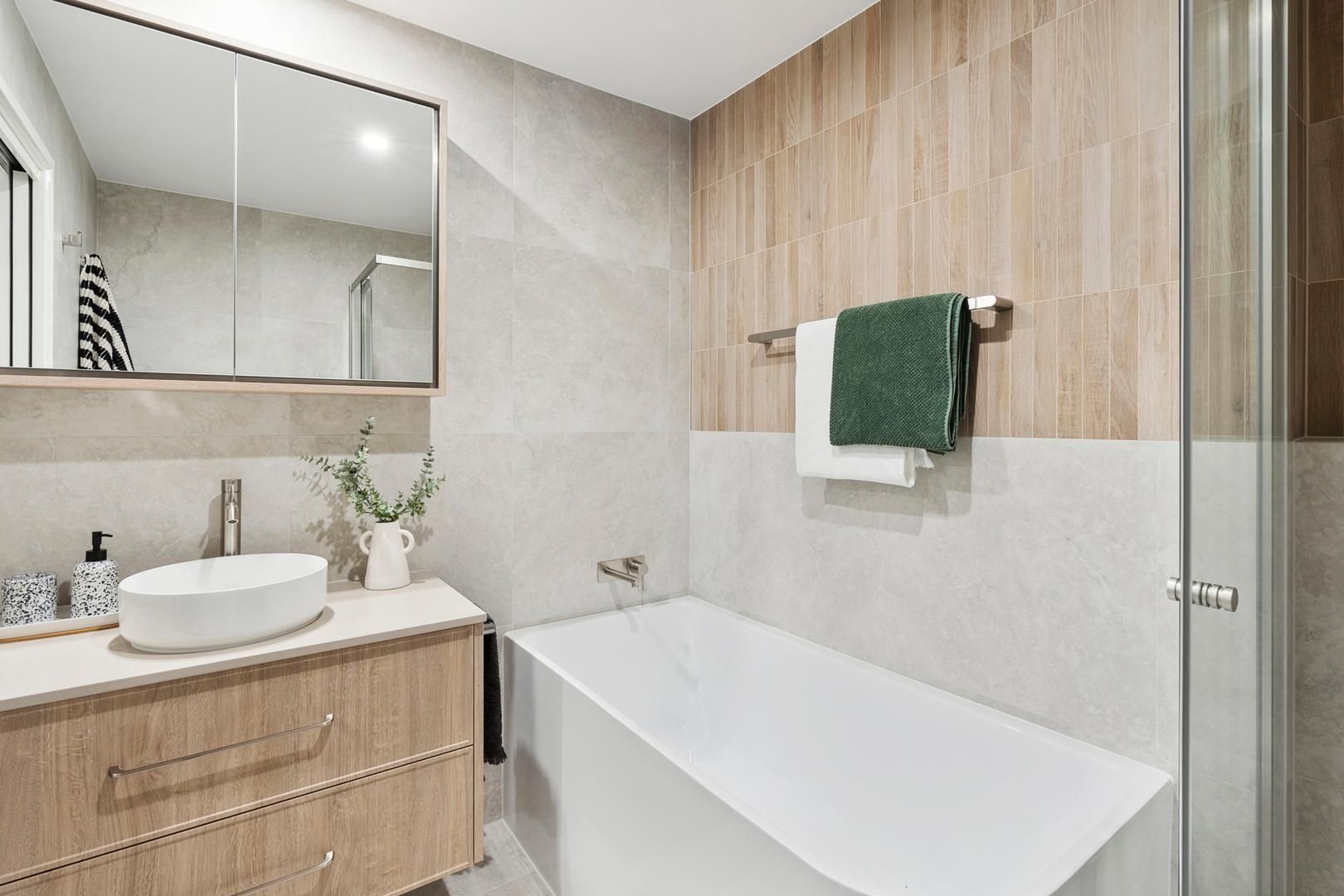 A bathroom with a bathtub , sink , mirror and shower.