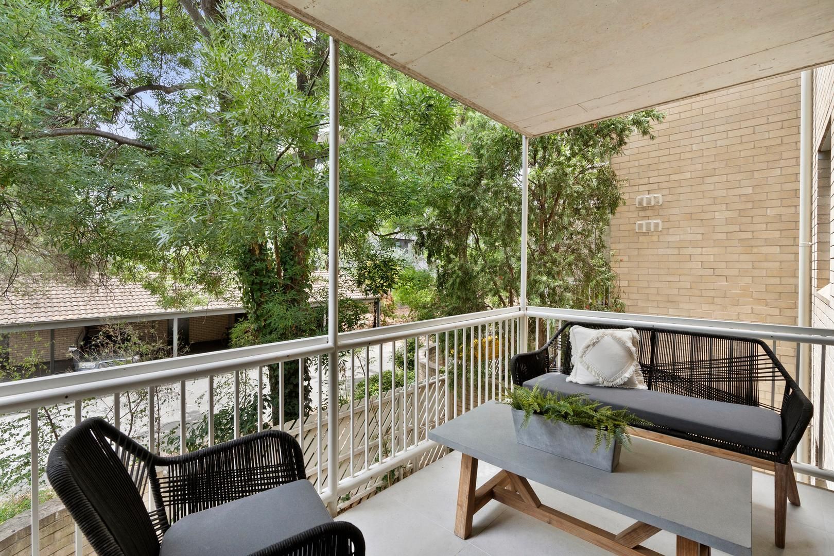 There is a balcony with a table and chairs on it.