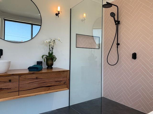 A bathroom with a sink and a walk in shower.