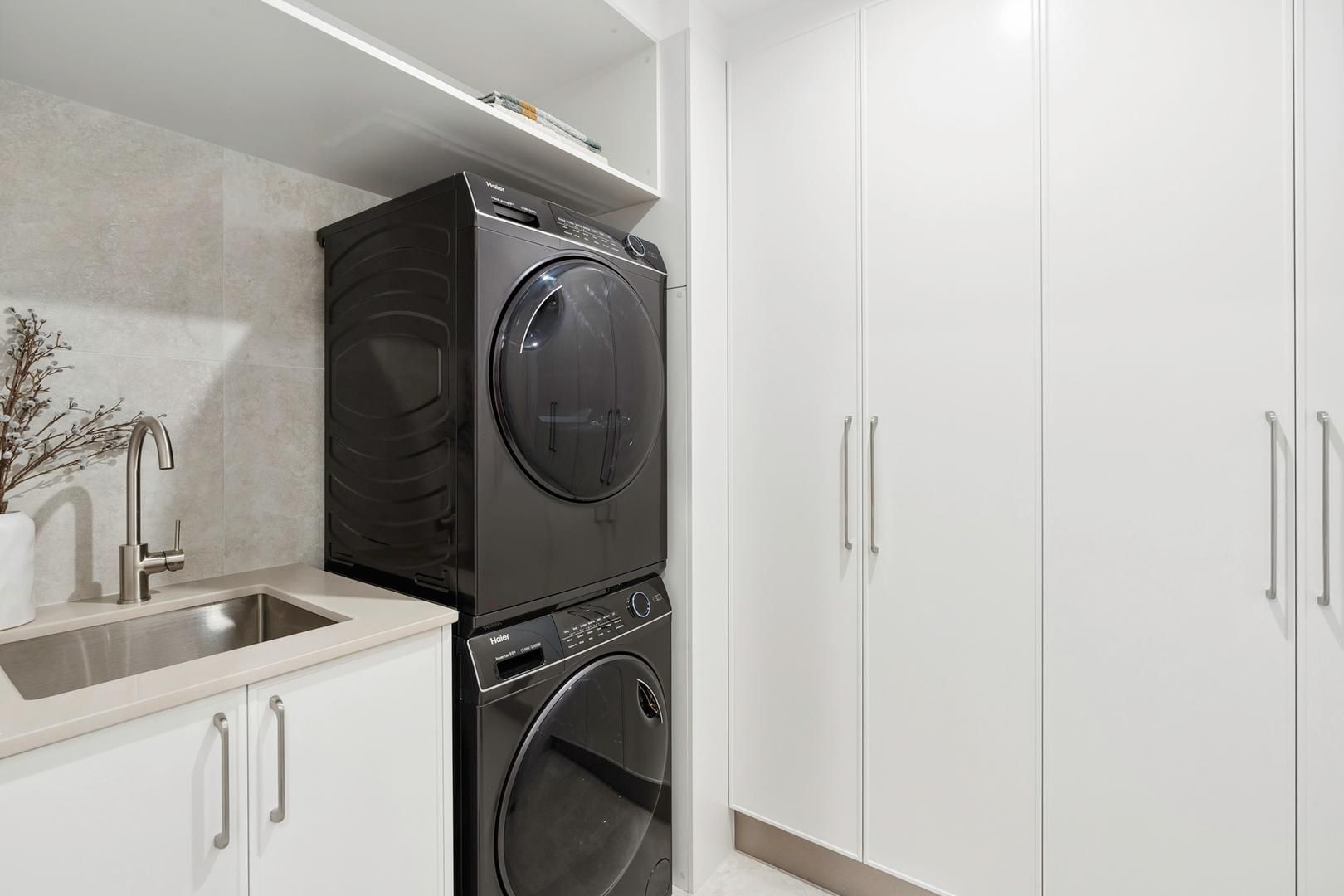 A laundry room with a washer and dryer stacked on top of each other.