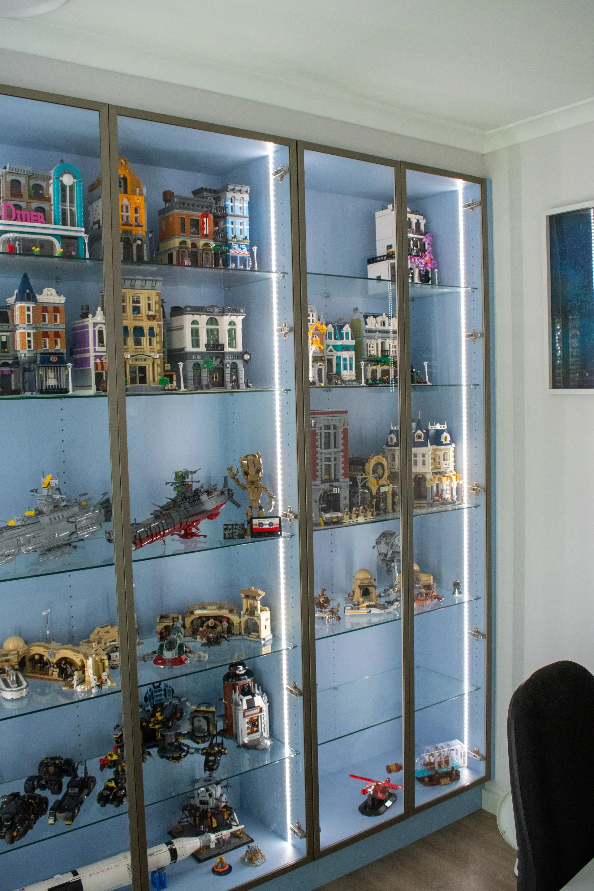 A display case filled with lots of lego toys in a room.