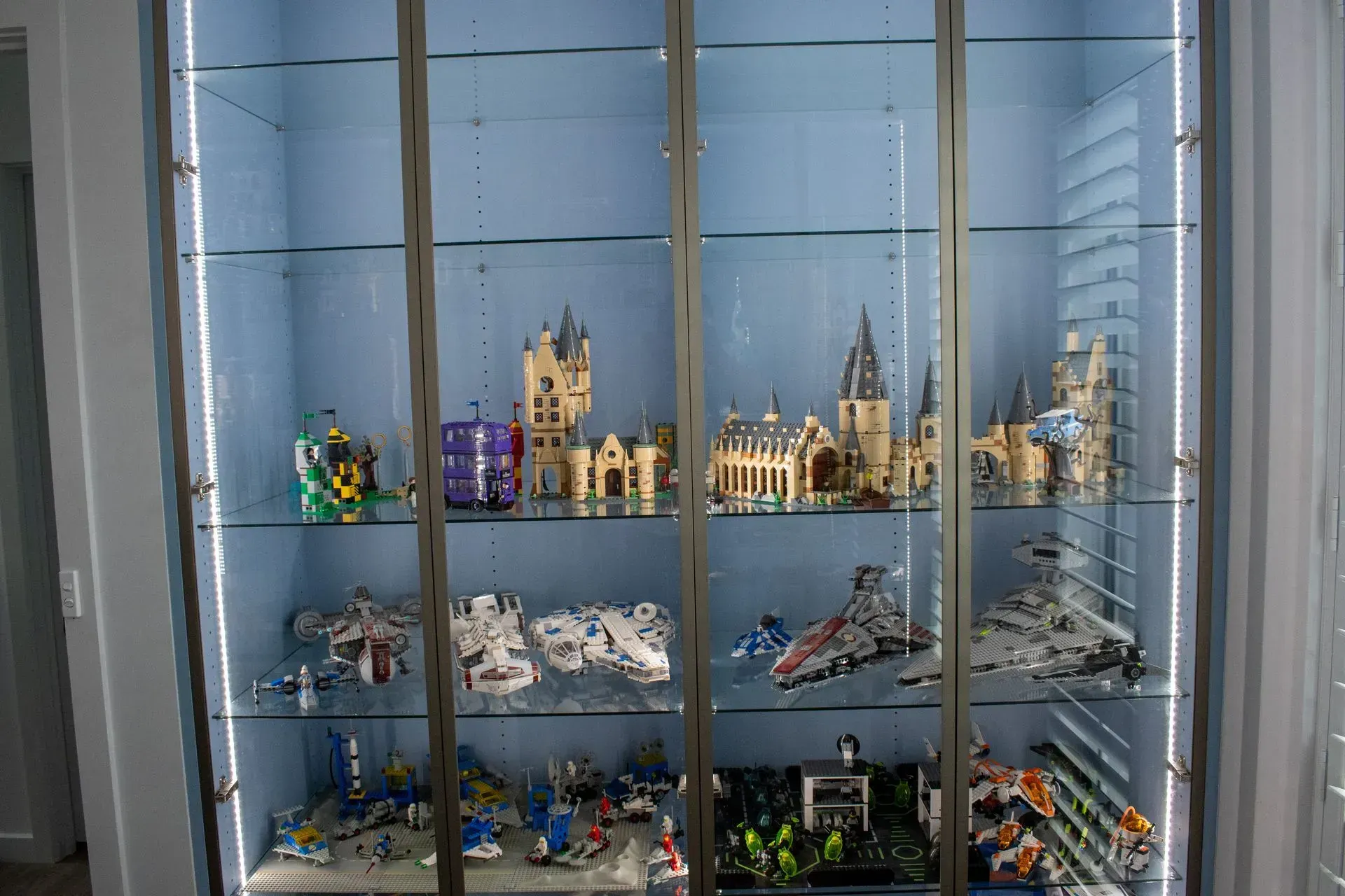 A glass cabinet filled with lots of lego toys.