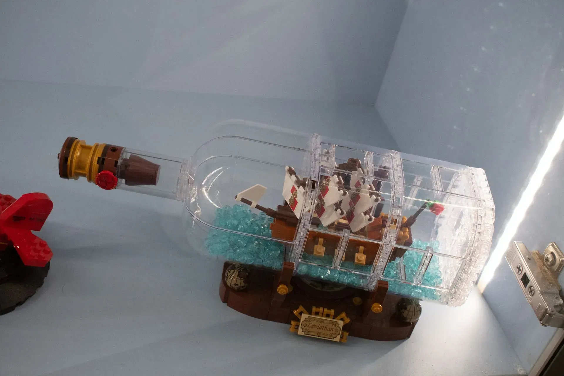 A lego ship in a bottle is sitting on a table.