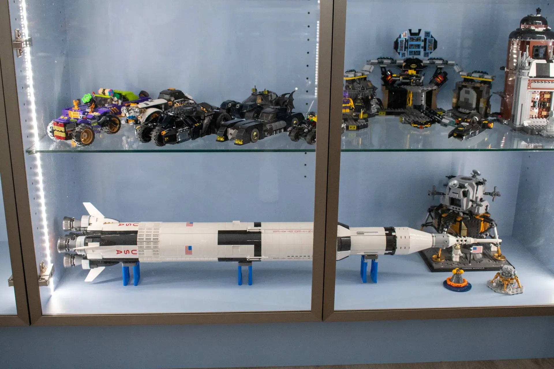 A lego rocket is sitting on top of a glass shelf.