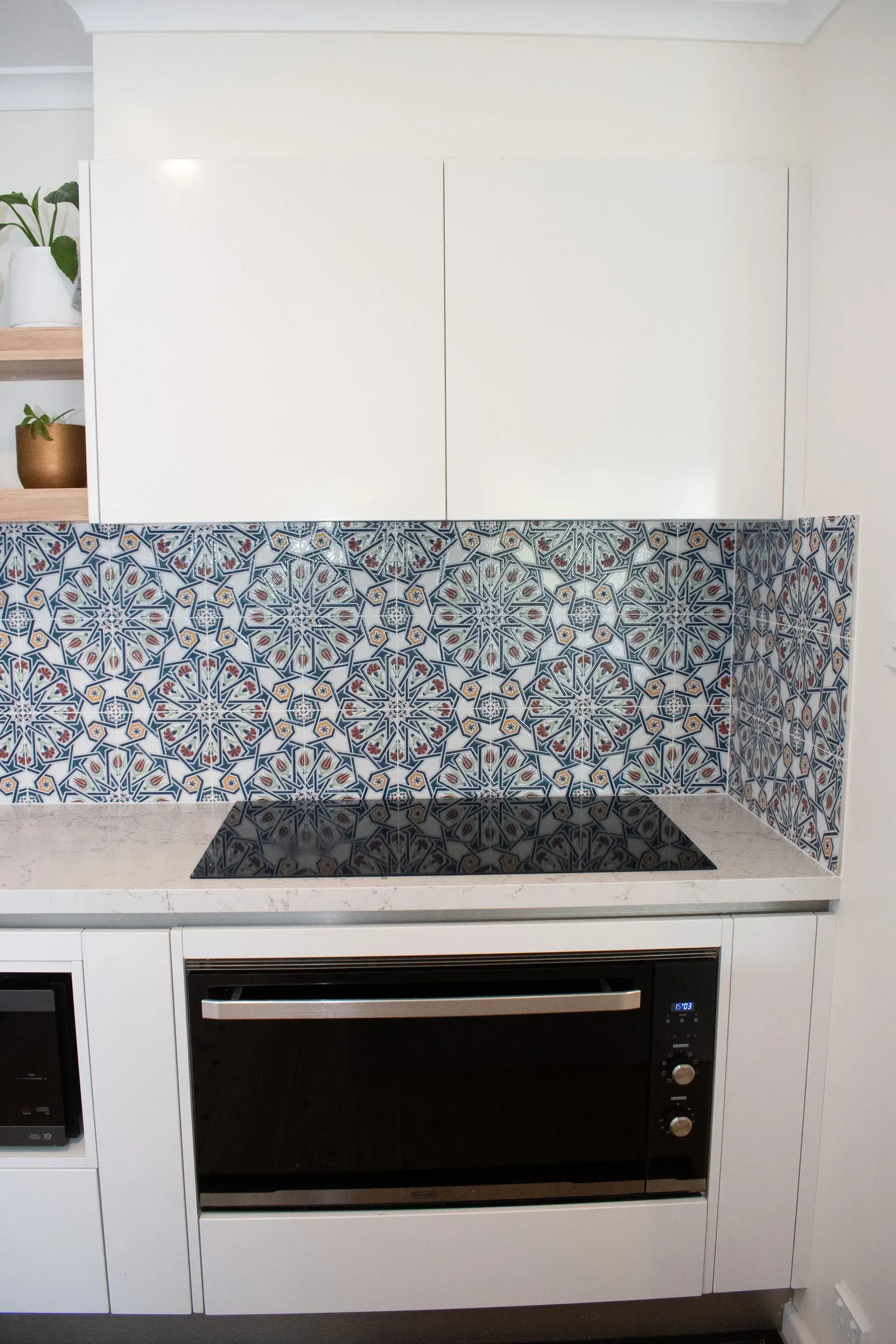 A kitchen with white cabinets and a black stove top oven.