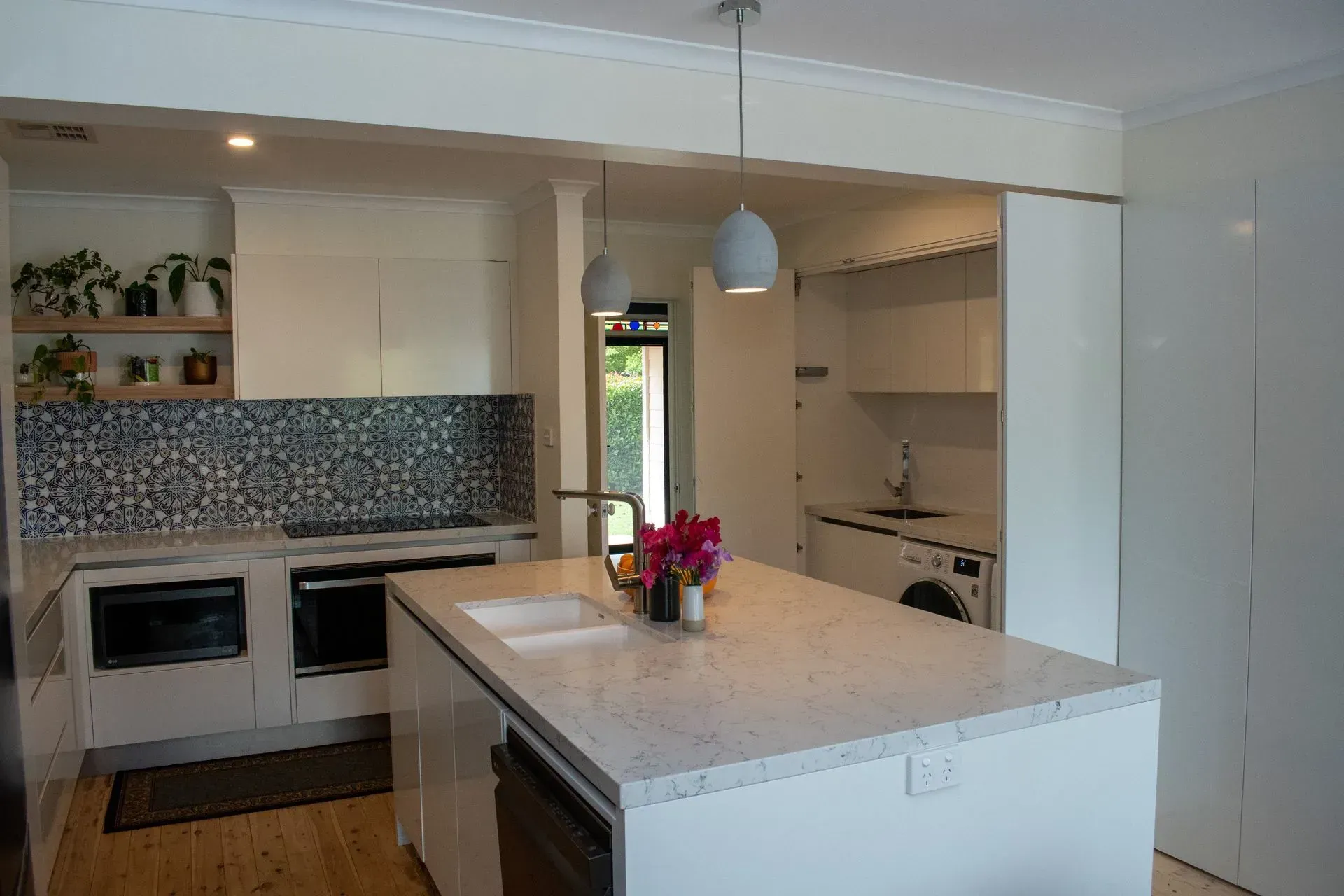 A kitchen with white cabinets and a large island in the middle.