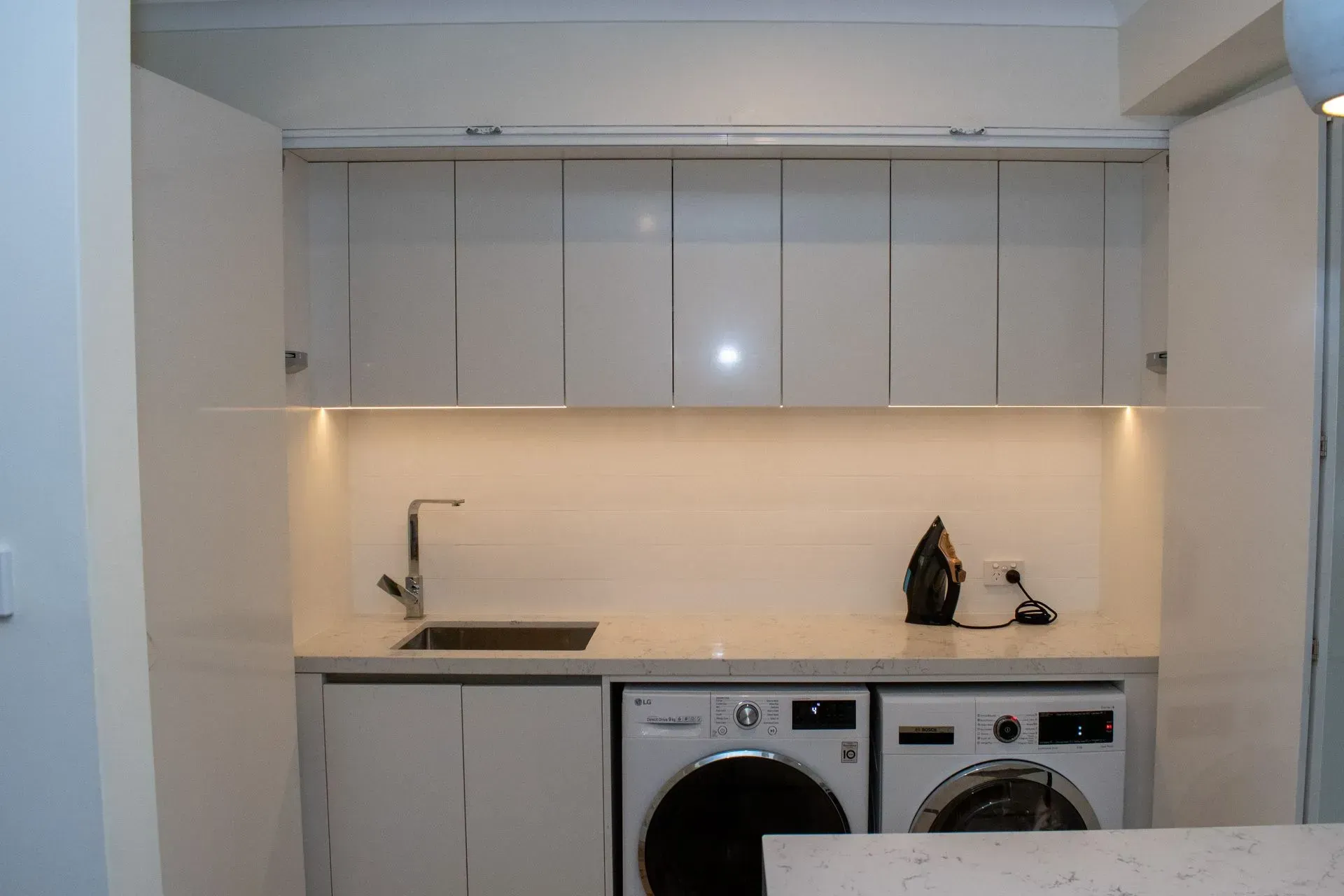 A laundry room with a washer and dryer and a sink