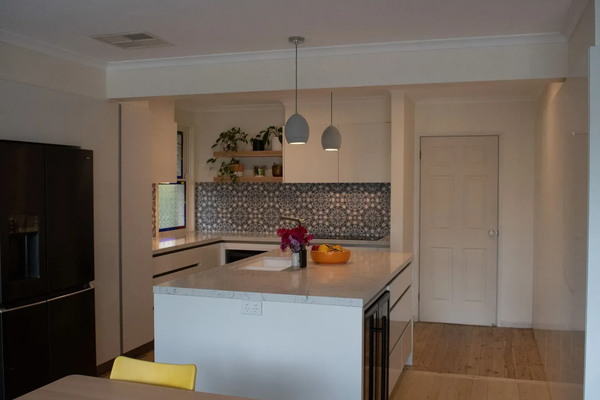 A kitchen with white cabinets and a large island in the middle.