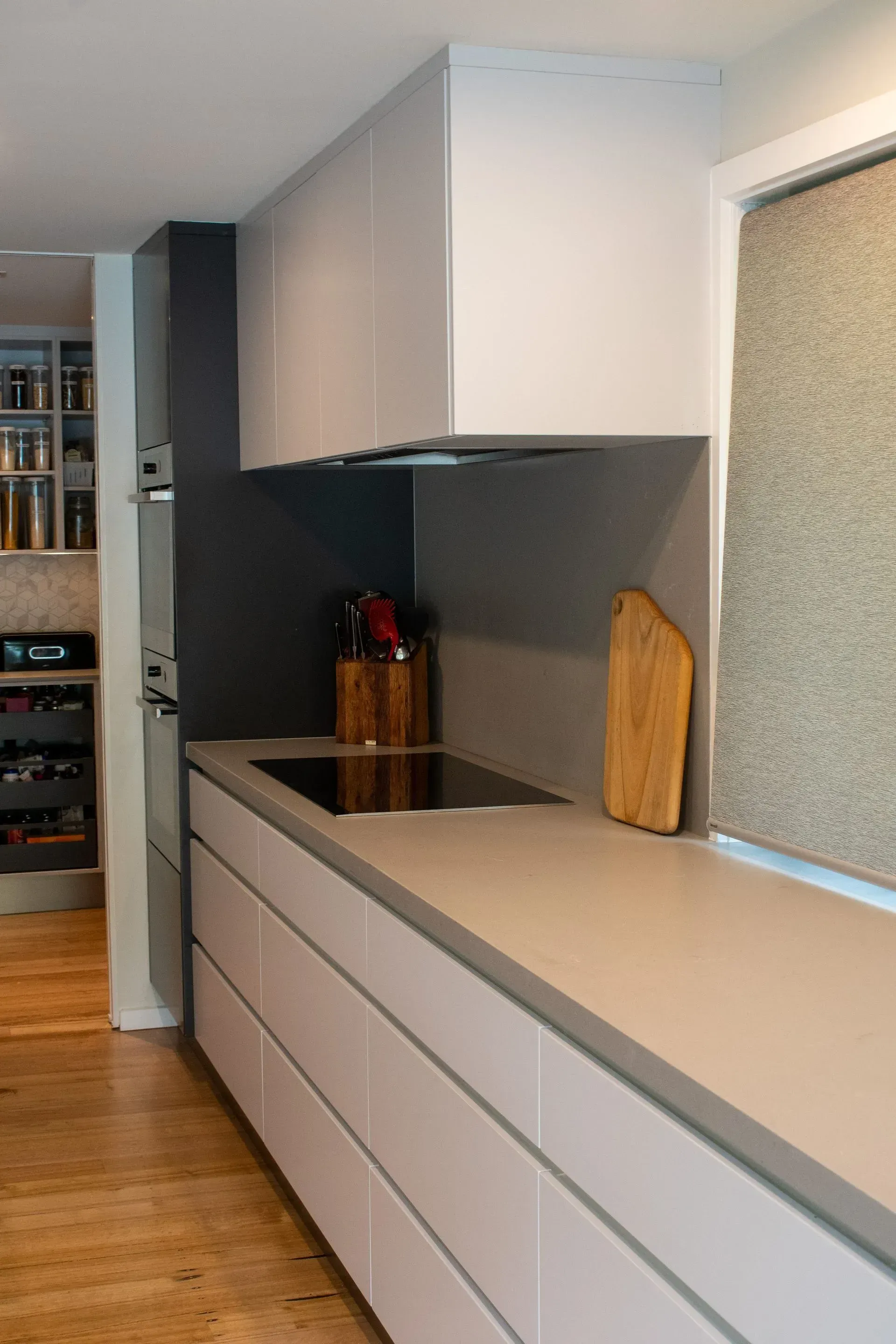 A kitchen with white cabinets and a stove top oven.