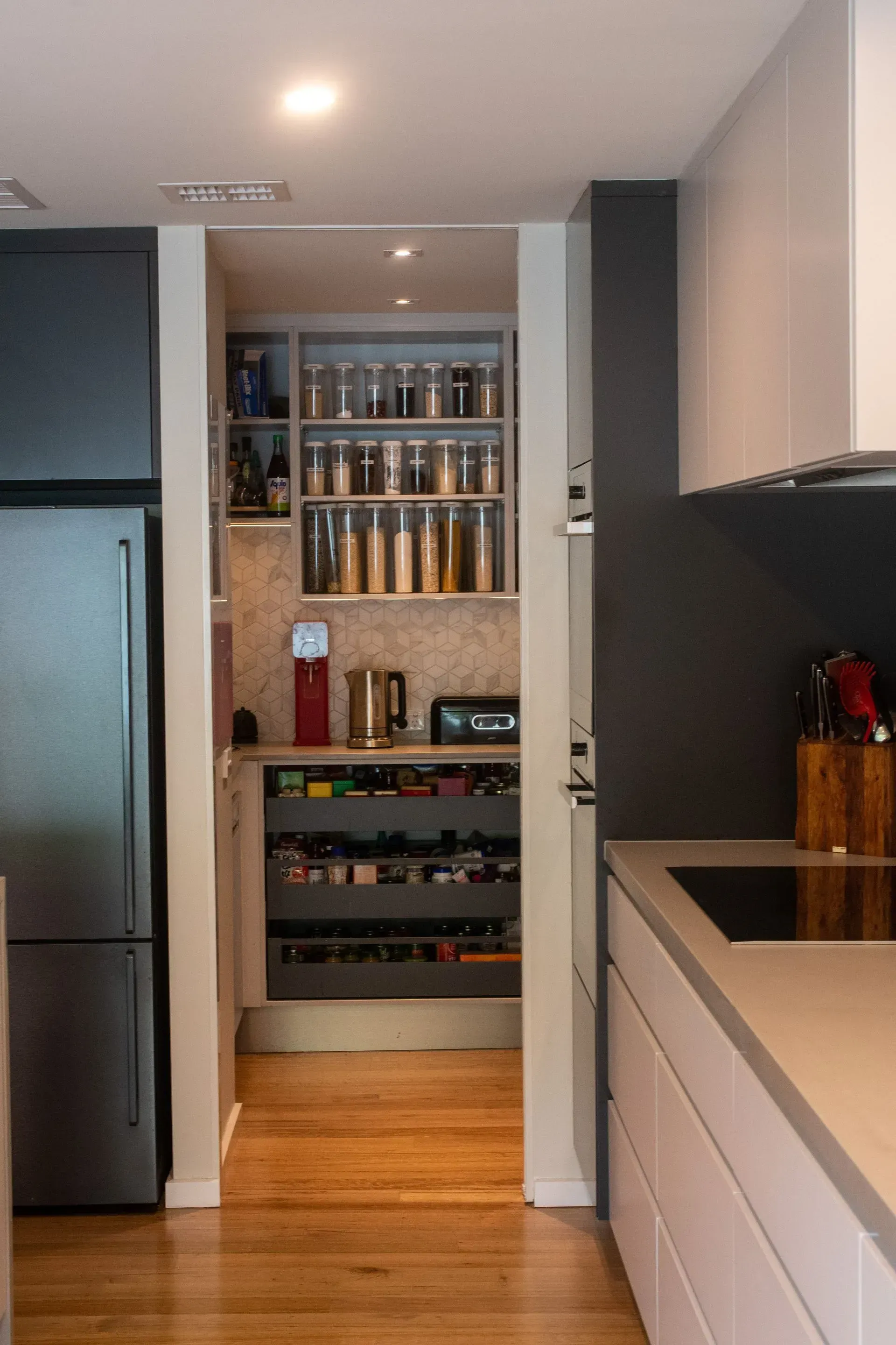 A kitchen with a pantry and a refrigerator.