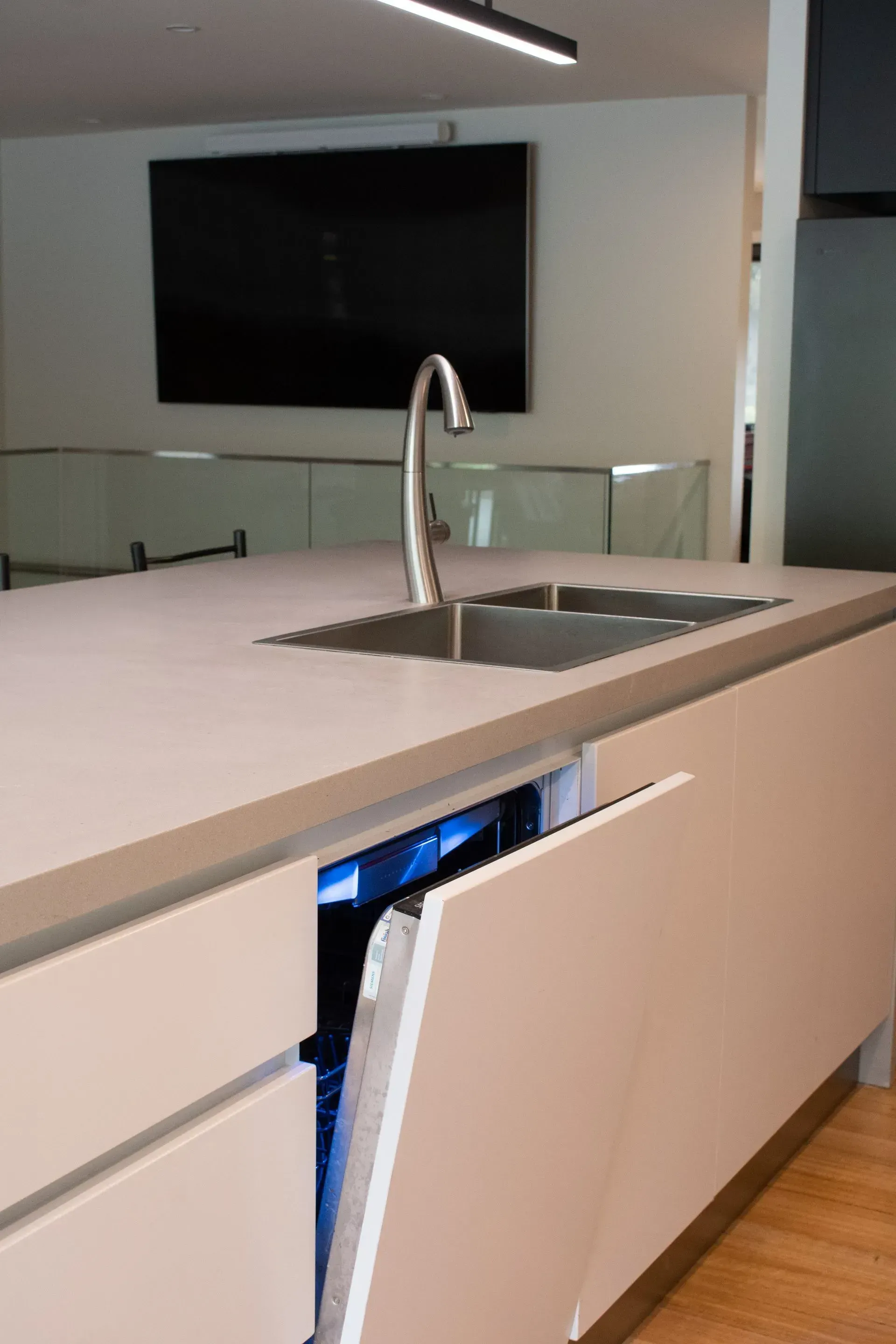 A kitchen with a sink and a dishwasher with the door open.