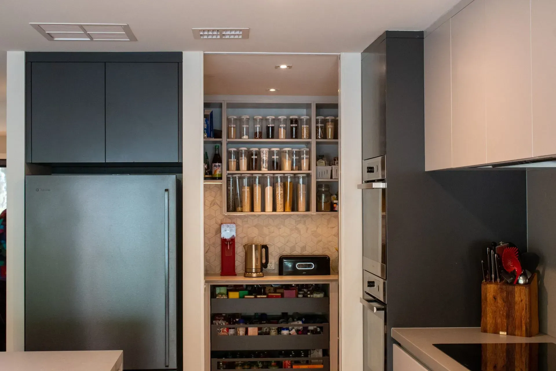 A kitchen with a stainless steel refrigerator and a wine rack