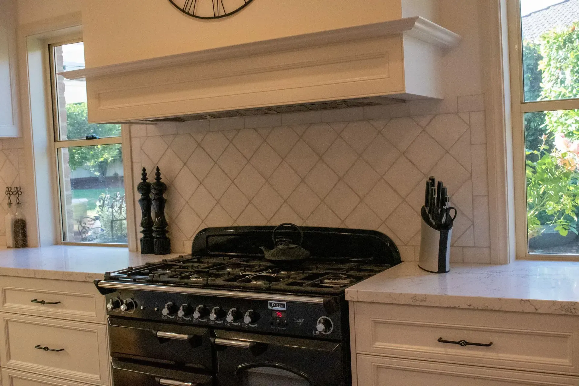 A kitchen with a stove and a clock above it