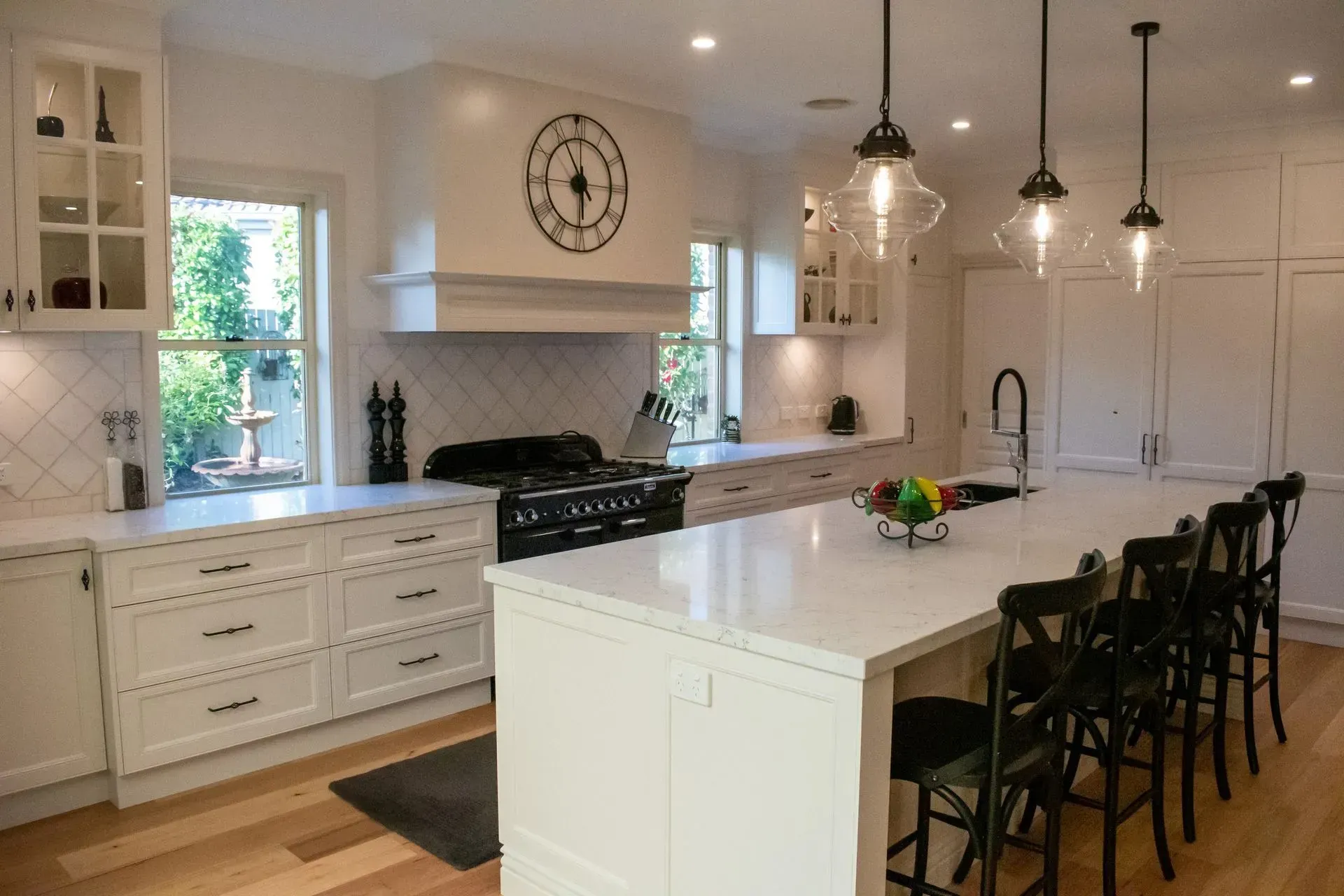 A kitchen with a large island and a clock on the wall.