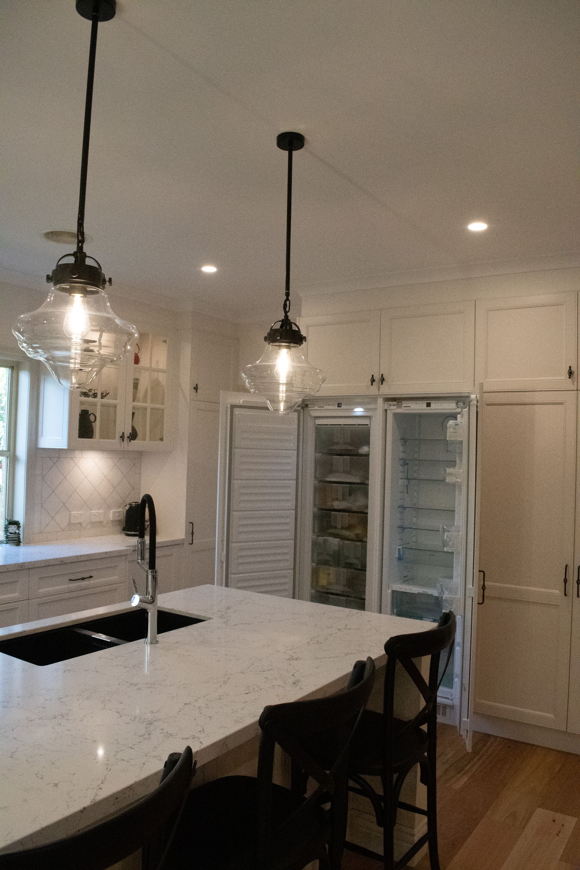 A kitchen with a large island and a refrigerator
