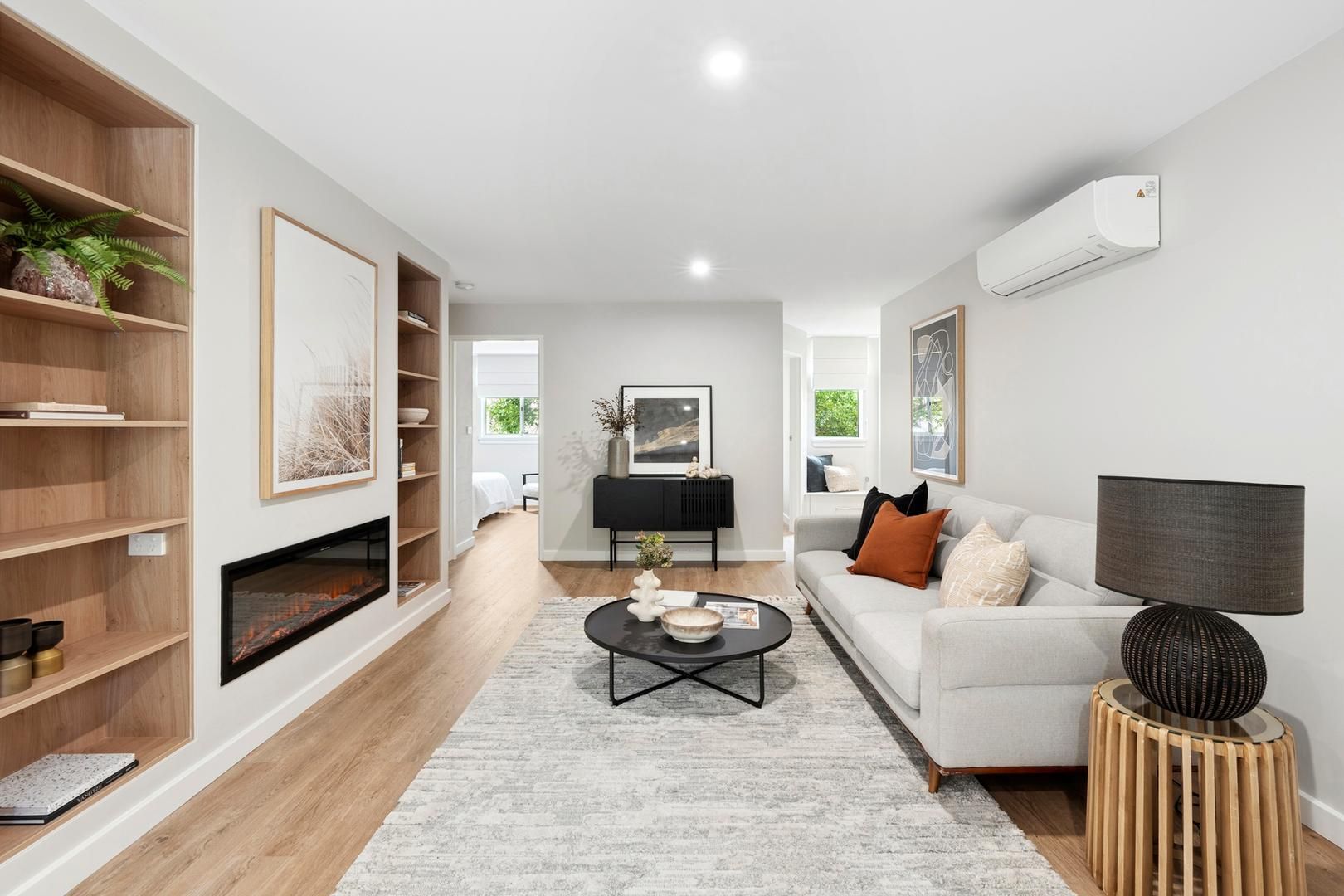 A living room with a couch , coffee table , lamp and fireplace.