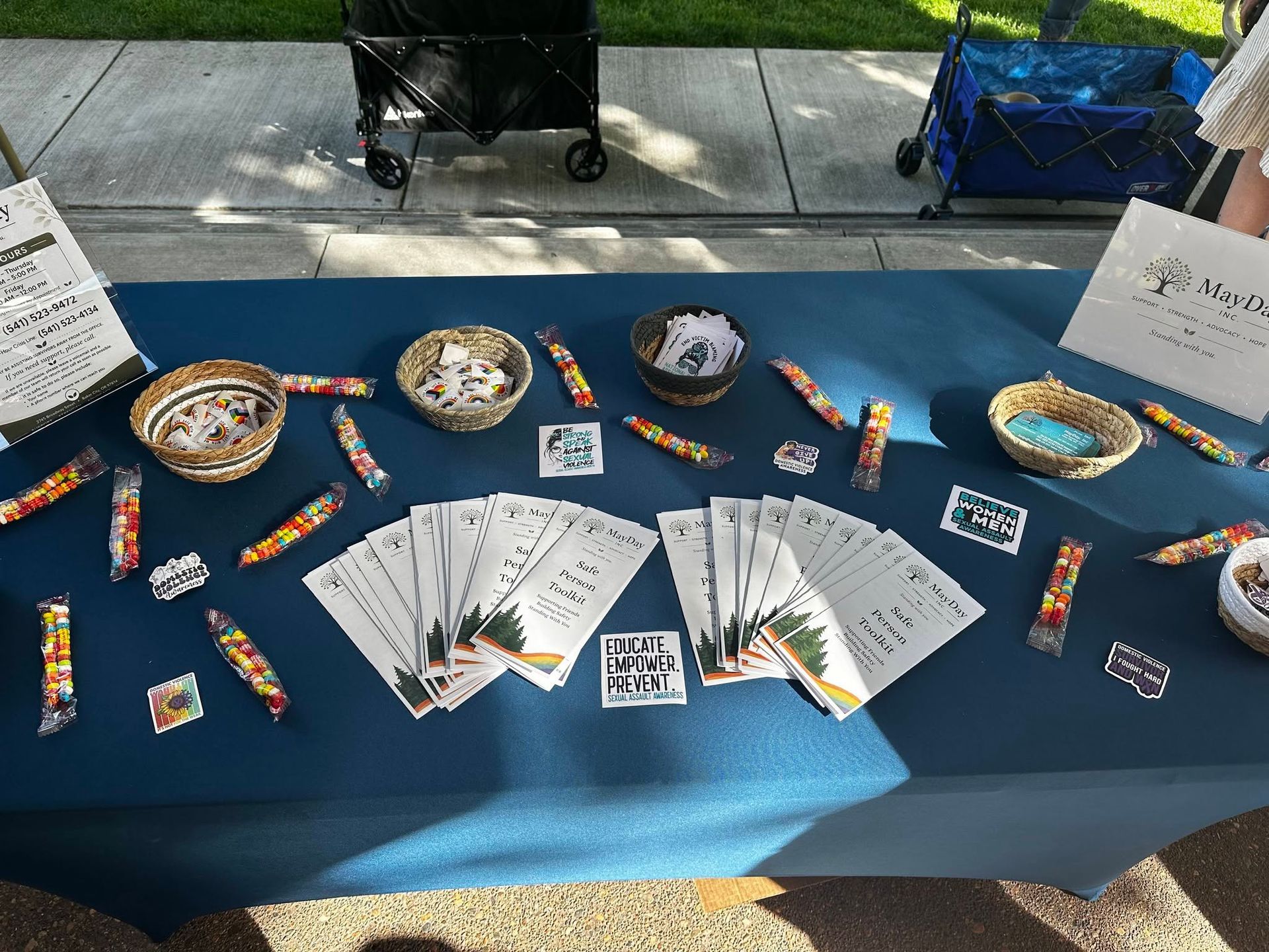 Outdoor table display with colorful candy, bowls, and printed cards on a blue tablecloth