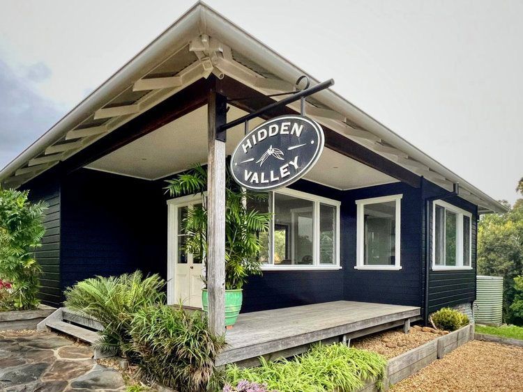 A Black House With A Sign That Says Hidden Valley — Professional Painters in Suffolk Park, NSW